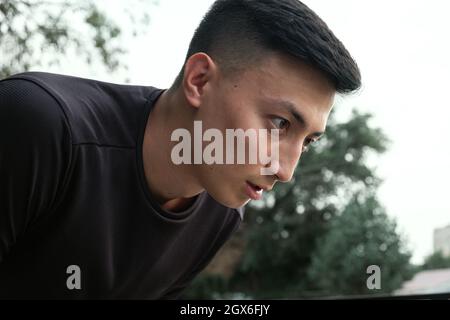 Shot of a handsome young man taking a moment to catch his breath after a morning run in the city Stock Photo