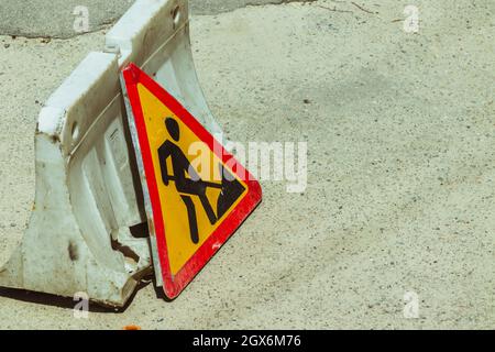 An old road sign that prohibits passage due to road repair work.  Stock Photo