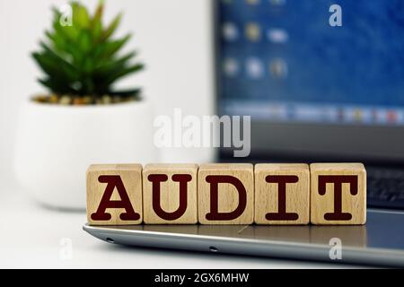 audit theme. wooden cubes with the word audit, on the background of laptop Stock Photo