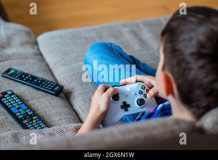 VIENNA, AUSTRIA - MAY 4th, 2018: Kid boy playing Xbox One. Xbox One is a line of eighth generation home video game consoles developed by Microsoft. Stock Photo