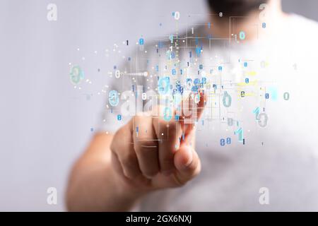A man tapping on a hologram of binary codes - digital transformation concept Stock Photo