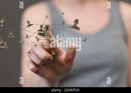 A woman tapping on a hologram of a network of people - networking concept Stock Photo