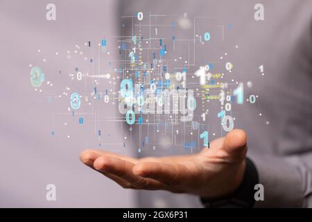 A hologram of binary codes on the palm of a businessman - digital transformation concept Stock Photo