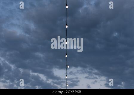 Abstract simple blue background for design with clouds and garland of light bulbs. Copy space for text Stock Photo