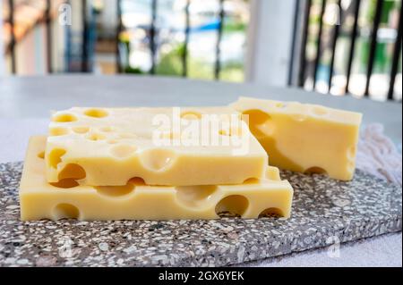 Cheese collection, semi-hard French cheese emmentaler with round holes made from cow milk close up Stock Photo
