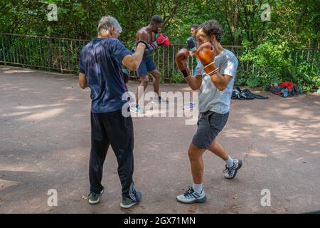 Paris, France - 09 18 2021: Park des Buttes Chaumont. Two men doing a boxing training in a park Stock Photo