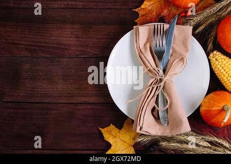 Happy Thanksgiving Day. Festive table setting on a brown wooden background. Place for text. Stock Photo
