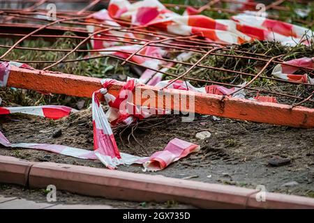 Broken warning tape. Aftermath of public unrest in the city. Destroyed barricades and fences. Stock Photo