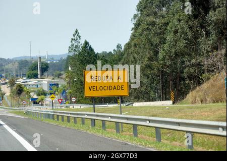 Sign on the highway in Portuguese in Brazil: 'Reduce speed'. Stock Photo