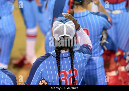 An Image Of A Softball Player Female Athlete Pitcher Is Winding Up To Deliver a Pitch To The Plate Stock Photo