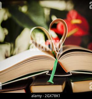 Open book and heart shaped paper pages, bright abstract background Stock Photo