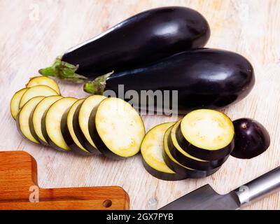Sliced aubergine on wooden table Stock Photo