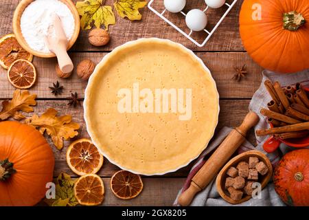 Pumpkin and food ingredients, spices, cinnamon and kitchen utencil on old rustic wooden background. Concept homemade baking for holiday. Cooking pumpk Stock Photo