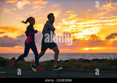 Running people training cardio together active friends jogging in early  morning dawn sunrise on beach. Run fit couple runners woman and man running  Stock Photo - Alamy