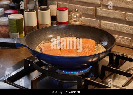 Fresh fillets of Solomon fish are fried in pan on gas stove Stock Photo