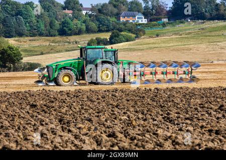 A John Deere 8330 four wheel drive tractor with a reversible six furrow plough Stock Photo