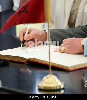 Prince Charles, Prince of Wales signs the visitors book during a visit to the 1st Brigade Infanterie Parachutiste in Rabat, Morocco on April 4, 2011. Stock Photo
