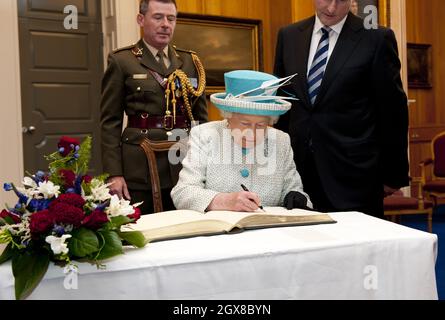 Queen Elizabeth ll signs the visitors book when she meets Irish Prime Minister Enda Kenny at the Government Buildings in Dublin on the second day of a historical State Visit to Ireland on May 18, 2011. **POOL PICTURES 28 DAY UK RESTRICTION *** Stock Photo