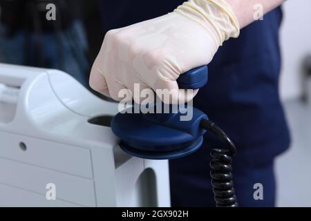 Resuscitator doctor holds an electrode in his hand. Preparing for defibrillation. Equipping a modern clinic. Life saving concept. Unrecognizable perso Stock Photo