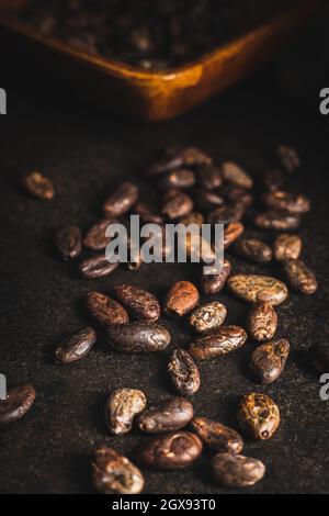 Roasted cocoa beans on black table. Stock Photo