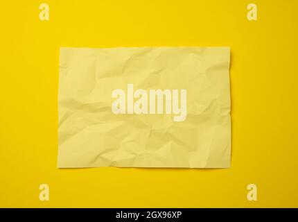 blank crumpled yellow sheet of paper on a yellow background, copy space. A4 format Stock Photo
