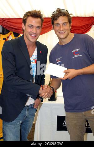 Will Young accepts a fundraising cheque at St Katherine's Dock from mountaineer Bear Grylss, whose team is aiming to break the world record of the first complete crossing of the North Atlantic Ocean in an open rigid inflatable boat. Proceeds are for the Prince's Trust. Stock Photo