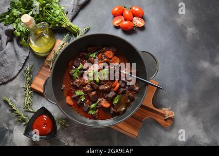 Beef Bourguignon in a pan. Stew  with red wine ,carrots, onions, garlic, a bouquet garni, and garnished with pearl onions, mushrooms and bacon. French Stock Photo