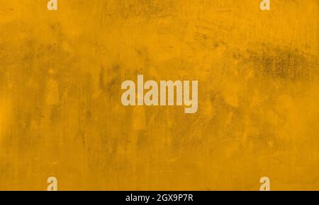 Grungy background wall in concrete or cement painting of gold yellow, dirty texture with details. Stock Photo