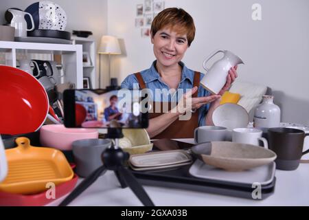 Asian woman blogger vlogger and online influencer recording video content on online marketing and selling and e-commerce for ceramic making and produc Stock Photo