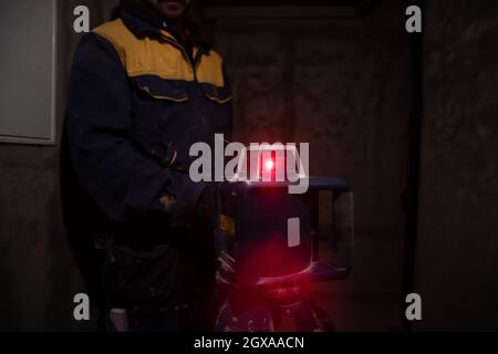 professional worker using laser level in a building under construction. Laser equipment at a construction site Stock Photo