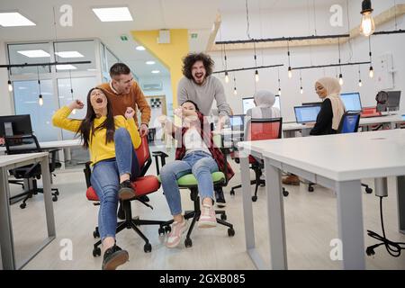 business people having fun while racing on office chairs Stock Photo