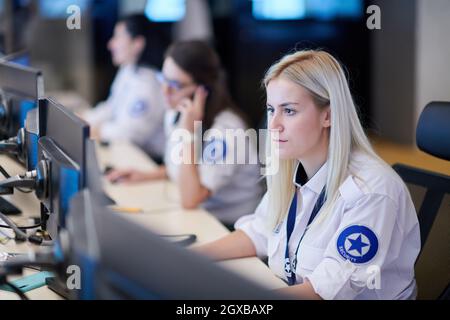 Female security operator working in a data system control room offices Technical Operator Working at  workstation with multiple displays, security gua Stock Photo