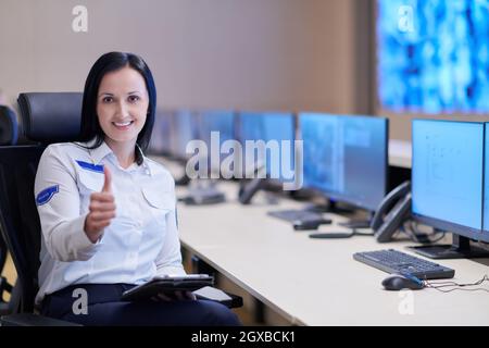 portrait of female security operator while working in a data system control room offices Technical Operator Working at  workstation with multiple disp Stock Photo