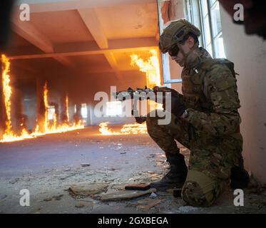 modern warfare soldier in action near window changing magazine and take cover urban environment Stock Photo