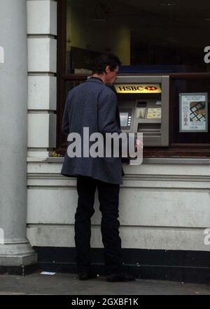 American actor/comedian Rich Hall draws cash out and forgets to grab his money before being reminded by an honest member of the public.   Stock Photo