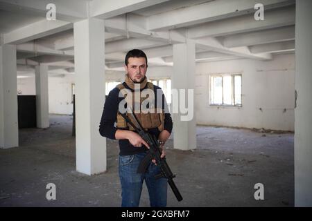 special agent  soldier portrait wearing  casual clothing with  protective army tactical gear  and weapon Stock Photo