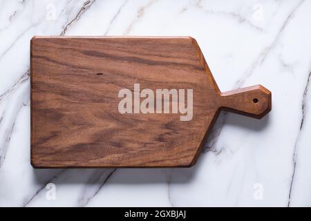 Handmade black walnut chopping board on stone table. Stock Photo