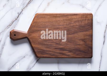 Handmade black walnut chopping board on stone table. Stock Photo