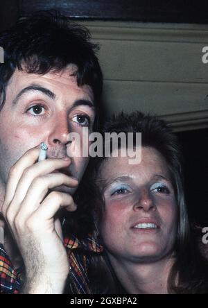 Paul McCartney smokes a cigarette and cuddles wife Linda at a party in  Oxford in 1972 Stock Photo