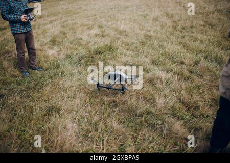 Man pilot controlling quadcopter drone with remote controller pad. Stock Photo