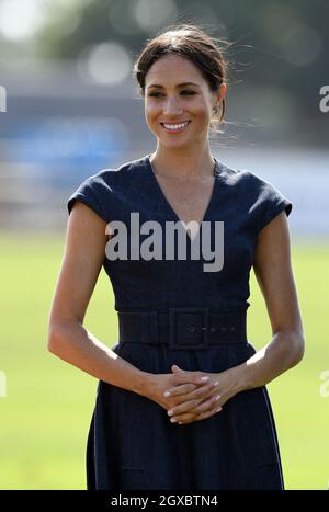 Meghan, Duchess of Sussex, wearing a navy blue dress by Carolina