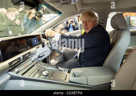 Manchester, England, UK. 5th Oct, 2021. PICTURED: Rt Hon Boris Johnson MP - UK Prime Minister seen doing a walk around of conference and seen cycling a electric e bike and also building a model zero carbon house model and operating a digger excavator. Scenes during the at the Conservative party Conference #CPC21. Credit: Colin Fisher/Alamy Live News Stock Photo