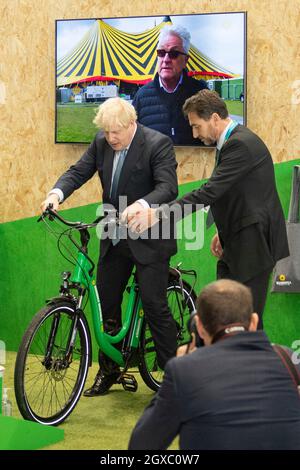 Manchester, England, UK. 5th Oct, 2021. PICTURED: Rt Hon Boris Johnson MP - UK Prime Minister seen doing a walk around of conference and seen cycling a electric e bike and also building a model zero carbon house model and operating a digger excavator. Scenes during the at the Conservative party Conference #CPC21. Credit: Colin Fisher/Alamy Live News Stock Photo