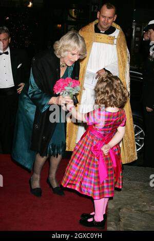 Camilla, Duchess of Cornwall receives a posy of flowers from Emelia Jones, daughter of singer and TV presenter Aled Jones, as she arrives for the presentation of 'The Story of Christmas' at St.George's Church on December19, 2006 in London, England. Stock Photo