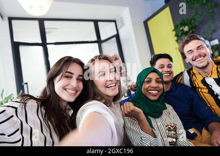 group of casual multiethnic business people during break from the work taking selfie picture while enjoying free time in relaxation area at modern ope Stock Photo