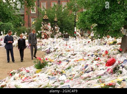 Prince Charles, Prince of Wales, Prince William and Prince Harry look at floral tributes to Diana, Princess of Wales outside Kensington Palace on September 5, 1997 in London. Stock Photo