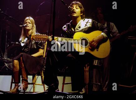 Paul McCartney and his wife Linda McCartney (1941 - 1998) on stage with Wings at London's Empire Pool on October 01, 1976 in London, England.  Stock Photo
