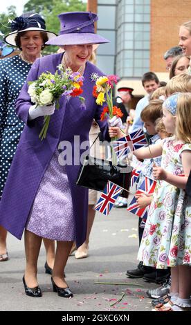 Queen Elizabeth II receives flowers from children following a Remembrance Service commemorating 25 years since the Falklands conflict at The Falkland Islands Memorial Chapel at Pangbourne College, Berkshire. Stock Photo