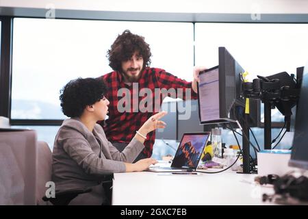 young software developers couple using laptop and desktop computer while writing programming code at modern creative startup office Stock Photo