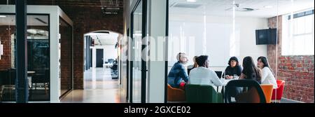 Diverse businesspeople having an important meeting in a modern workplace. Creative businesspeople having a discussion while sitting together in a meet Stock Photo